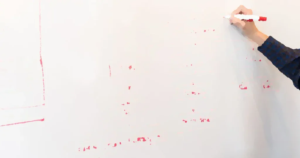A person creates a flowchart diagram with red pen on a whiteboard, detailing plans and budgeting.