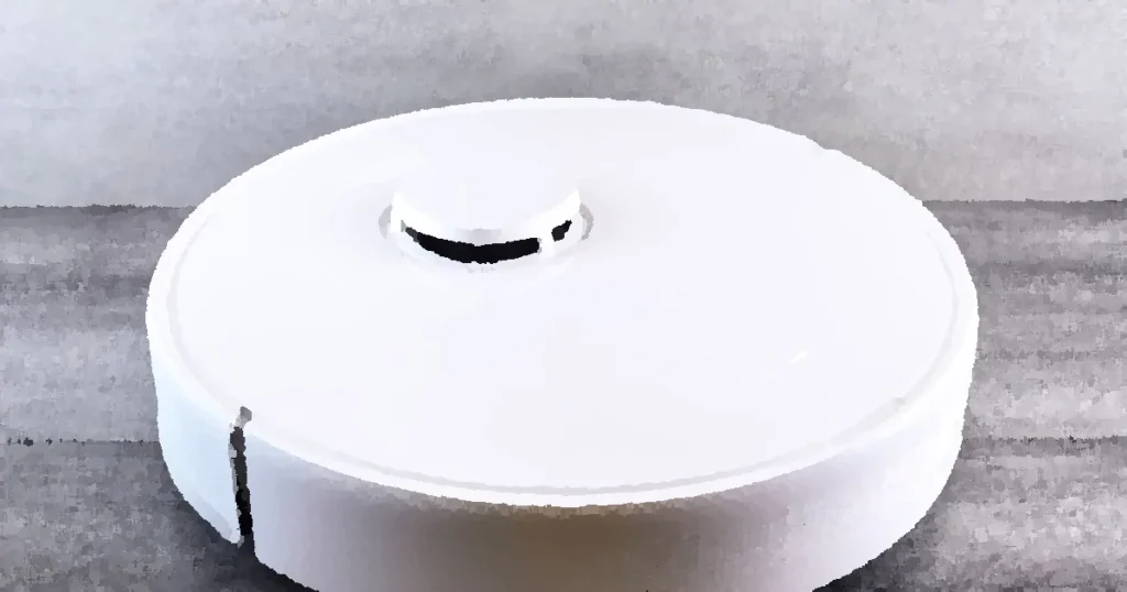 Sleek white robot vacuum cleaner on a wooden floor, perfect for smart home setups.