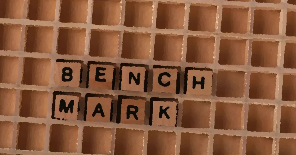 Wooden letter tiles spelling 'BENCHMARK' placed on a grid-like wooden background.