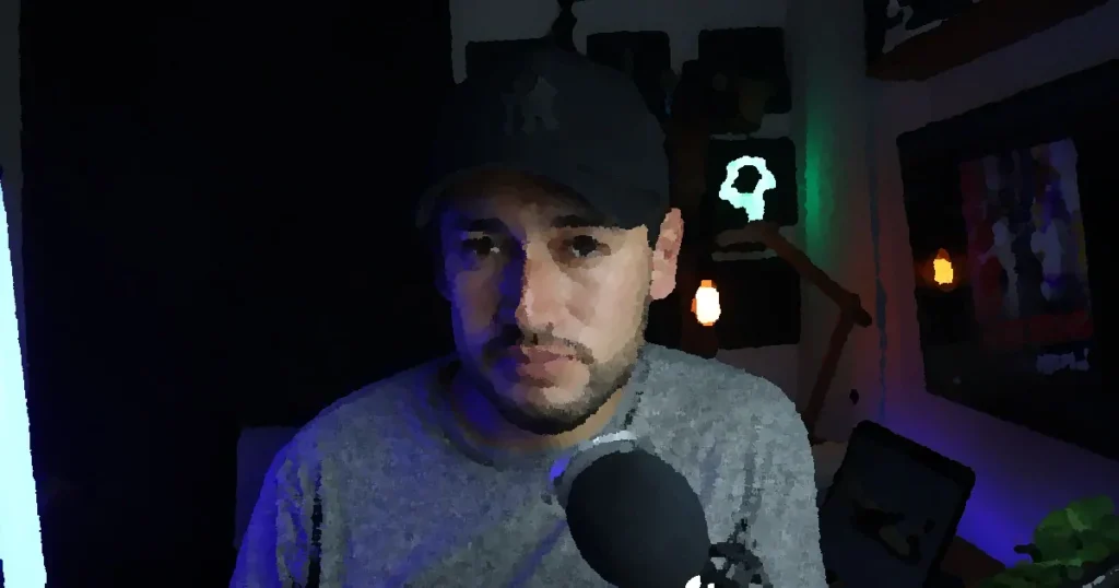 Male content creator in a home studio setup with microphone and soft lighting.