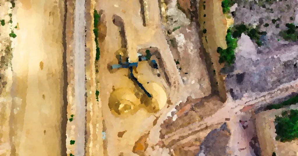 An aerial shot of an open-pit mine with machinery and pathways visible, surrounded by landscape.