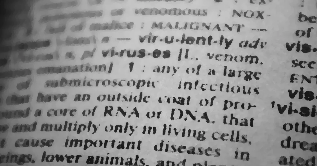 Black and white close-up of a dictionary page focusing on the definition of 'virus'.