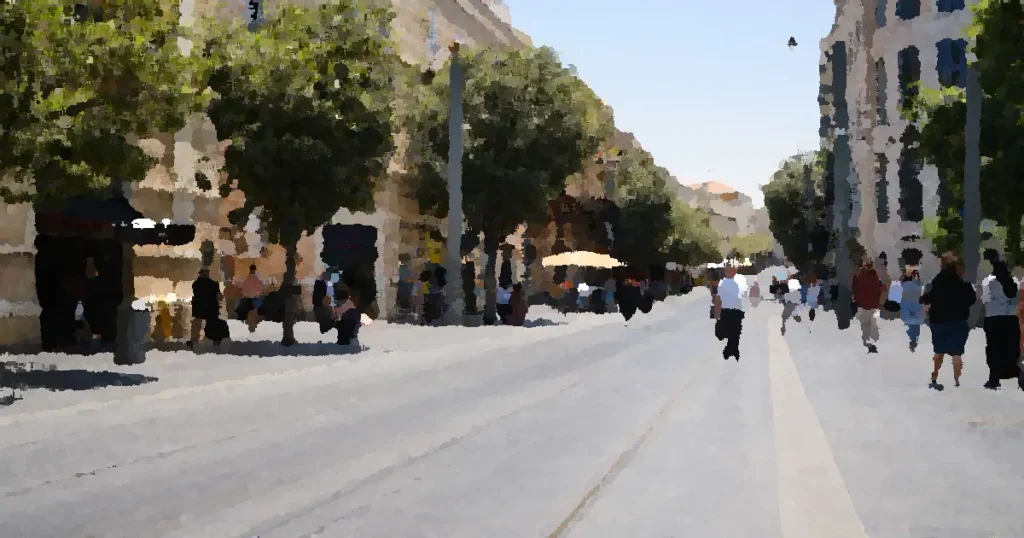Lively day on Jaffa Street, Jerusalem with pedestrians and tram tracks.