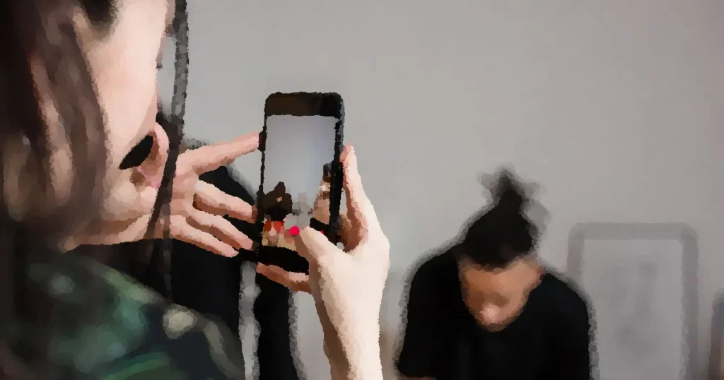 Close-up of a person recording a video with a smartphone indoors, focusing on creative content creation.