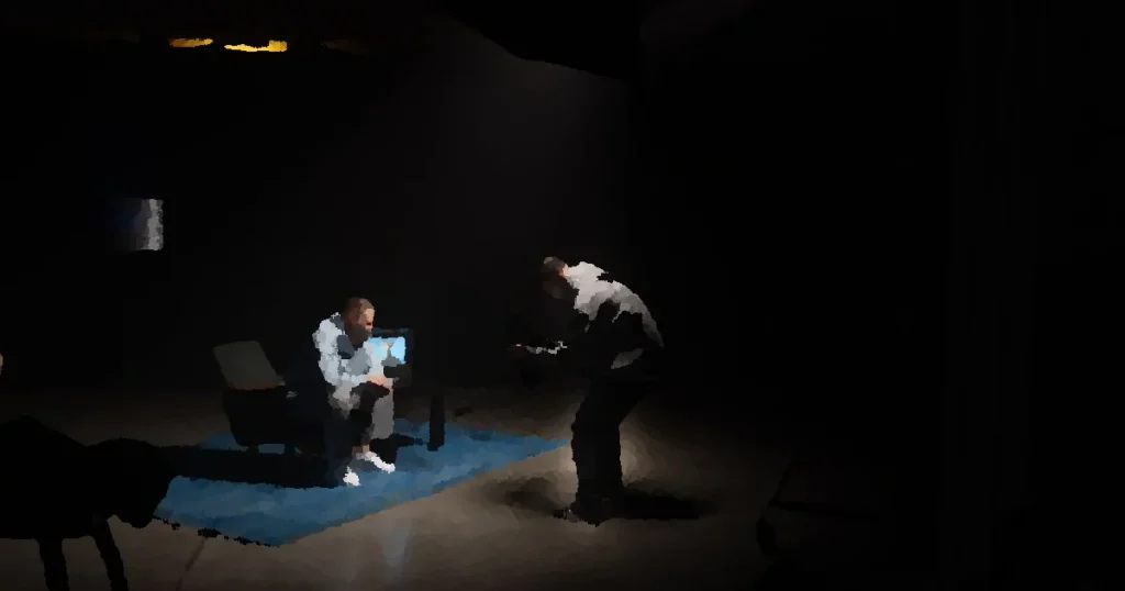 Film production shoot indoors with cinematographer filming an actor sitting, studio lighting.