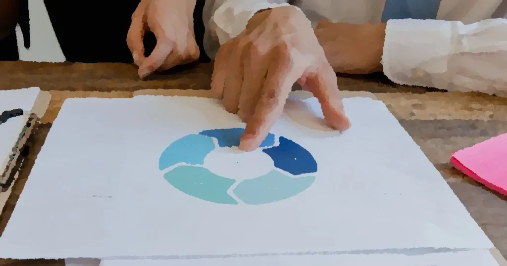 Close-up of hands pointing to a circular business strategy plan on paper.