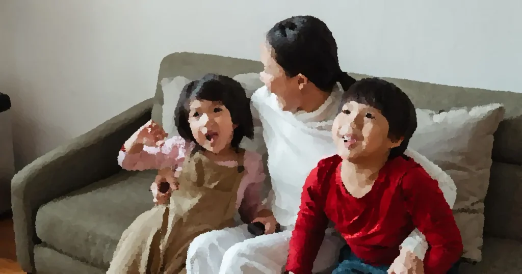 From above of cheerful little ethnic children spending time together with mother and having fun sitting on sofa