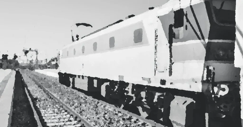 Vintage train in Kenitra, Morocco captured in grayscale, showing railway tracks.