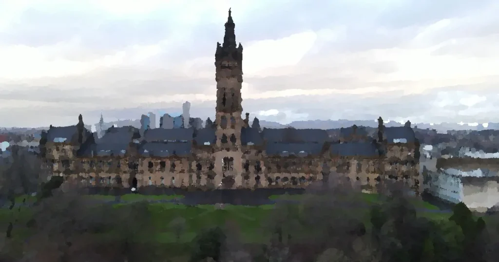 Aerial view of the historic University of Glasgow building surrounded by green trees under a cloudy sky.